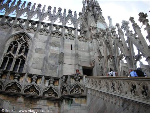 Tourists on the marble rooftop terraces of Milan Cathedral among gothic spires