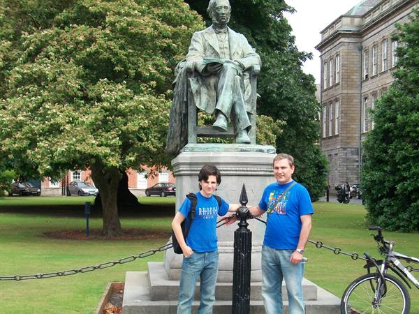 Two tourists beside the bronze statue in Trinity College campus