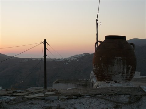Ancient terracotta amphora on a Cycladic rooftop at dusk