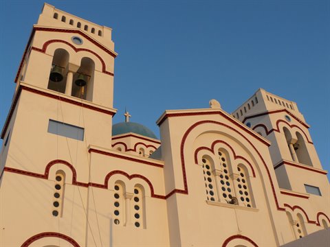 White church with twin bell towers and blue dome, Santorini