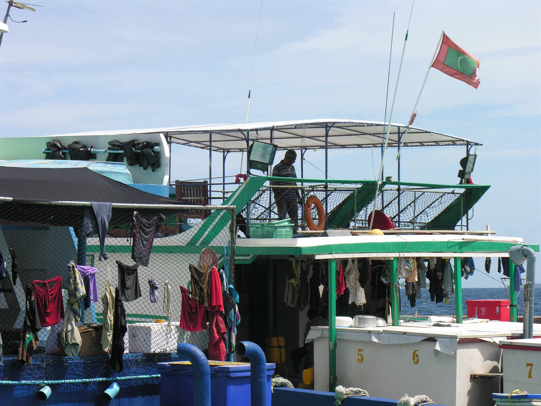 Dhoni con bandiera delle Maldive, panni stesi ad asciugare sul ponte