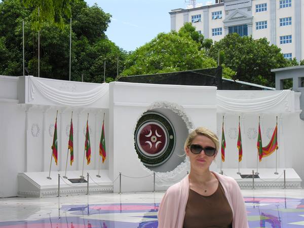 Tourist in front of Jinnah's white marble mausoleum with flags in Karachi