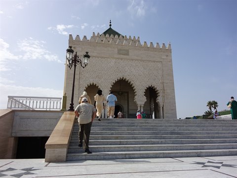 Turisti salgono le scale bianche del Mausoleo Mohammed V a Rabat