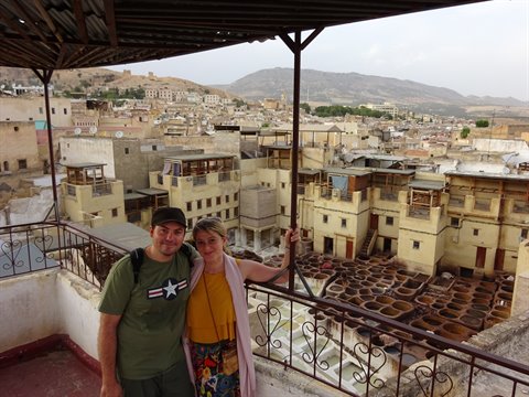 Coppia sulla terrazza sopra le concerie di Fes, vasche di pietra pienamente visibili