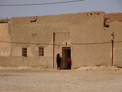 Donne all'ingresso di una casa in terra cruda sotto il sole