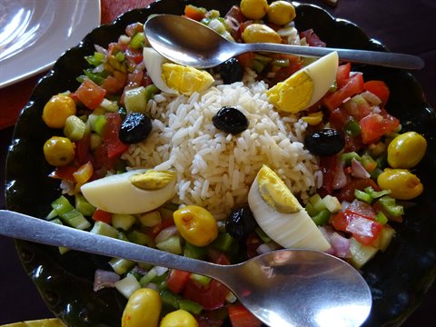 Insalata di riso con uova, olive e pomodori servita a tavola
