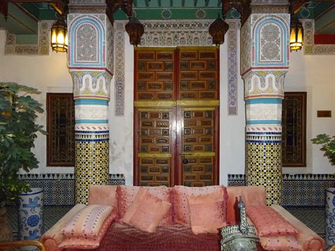Riad a Fes: colonne di zellige, porte in cedro intagliato e divani rosa