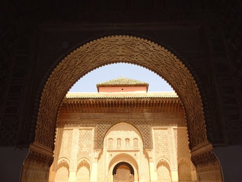 Arco intagliato in legno e stucco incornicia il patio della medersa di Marrakech