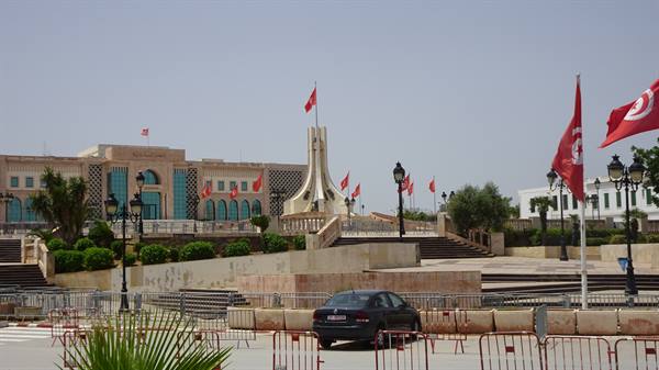 Kasbah Square in Tunis: white monument, Tunisian flags, parked car
