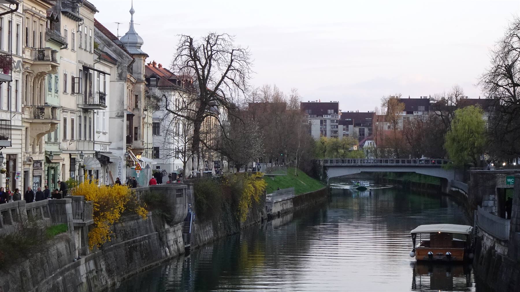 Fiume Ljubljanica a Lubiana, barche ferme, edifici antichi e passerella