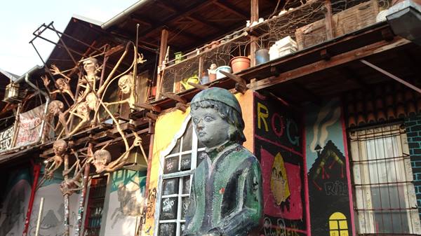 Child statue before sculptures and graffiti at Metelkova, Ljubljana
