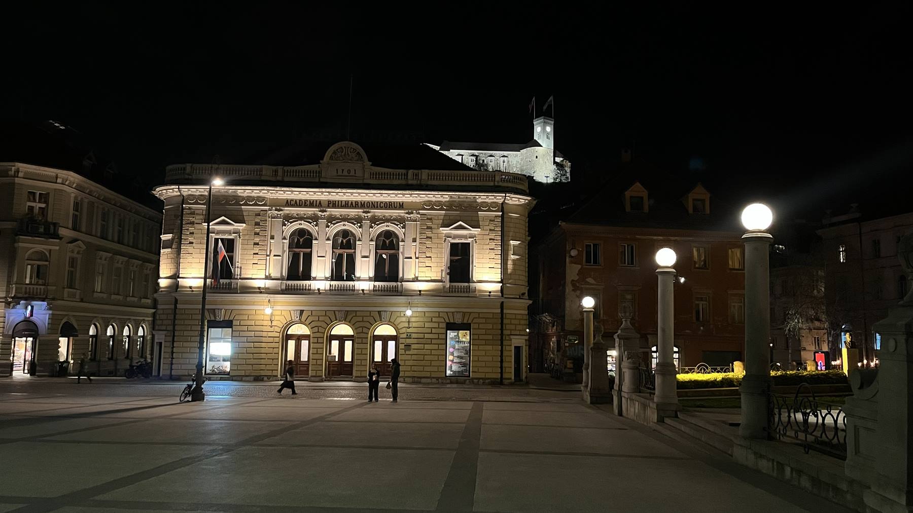 Piazza Prešeren a Lubiana di notte, palazzo illuminato e cielo scuro
