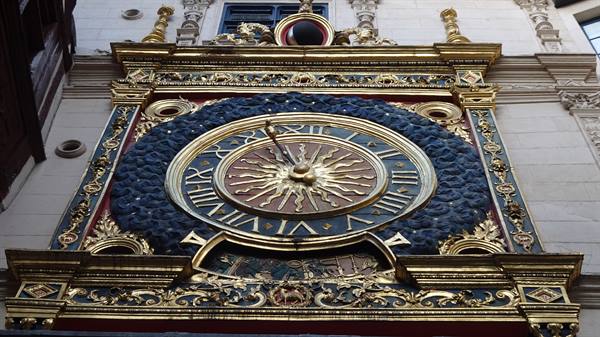 Golden astronomical clock with radiant sun on Rouen facade