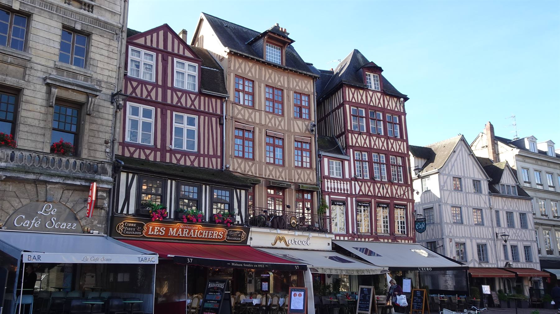 Case a graticcio rosse e caffè con tende nella piazza di Rouen