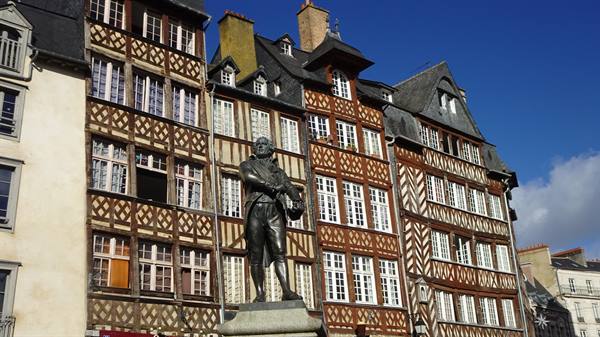 Bronze statue before timber-framed houses in Rennes, Place du Champ-Jacquet