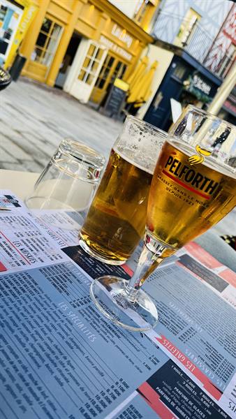 Pelforth beers on a menu at a brasserie table