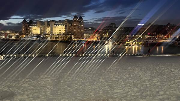 Marble roofs of Oslo Opera House, light trails and illuminated buildings across the water