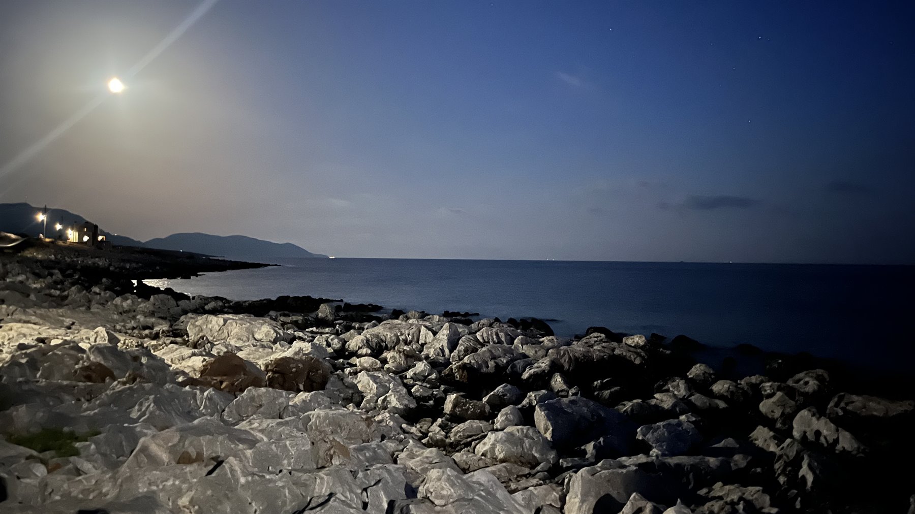 La luna accarezza le pietre bianche e il mare tace, incantato.
