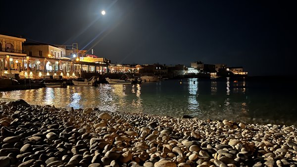 A full-moon evening, the pebble beach shines under the lights of the village.