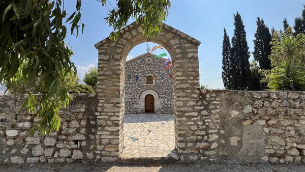 Through the stone arch, a little church guards silences and wonders.