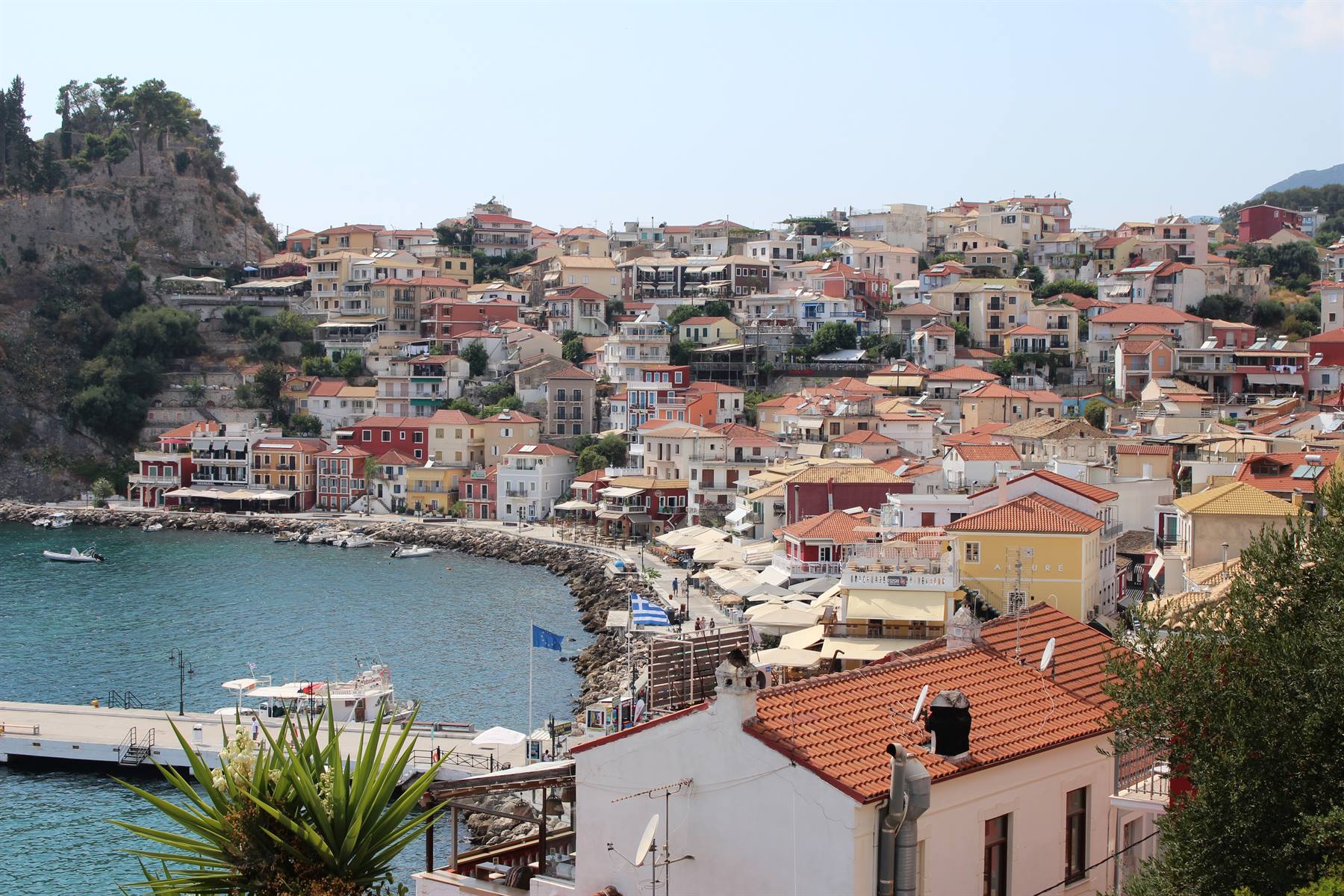 Piccolo porto greco, case colorate e mare tranquillo: cuore pieno.