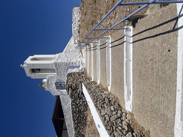 Under the blue sky, up the steps towards the little white church.
