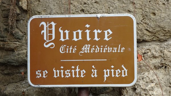 Brown Yvoire sign reading Cité Médiévale on stone wall