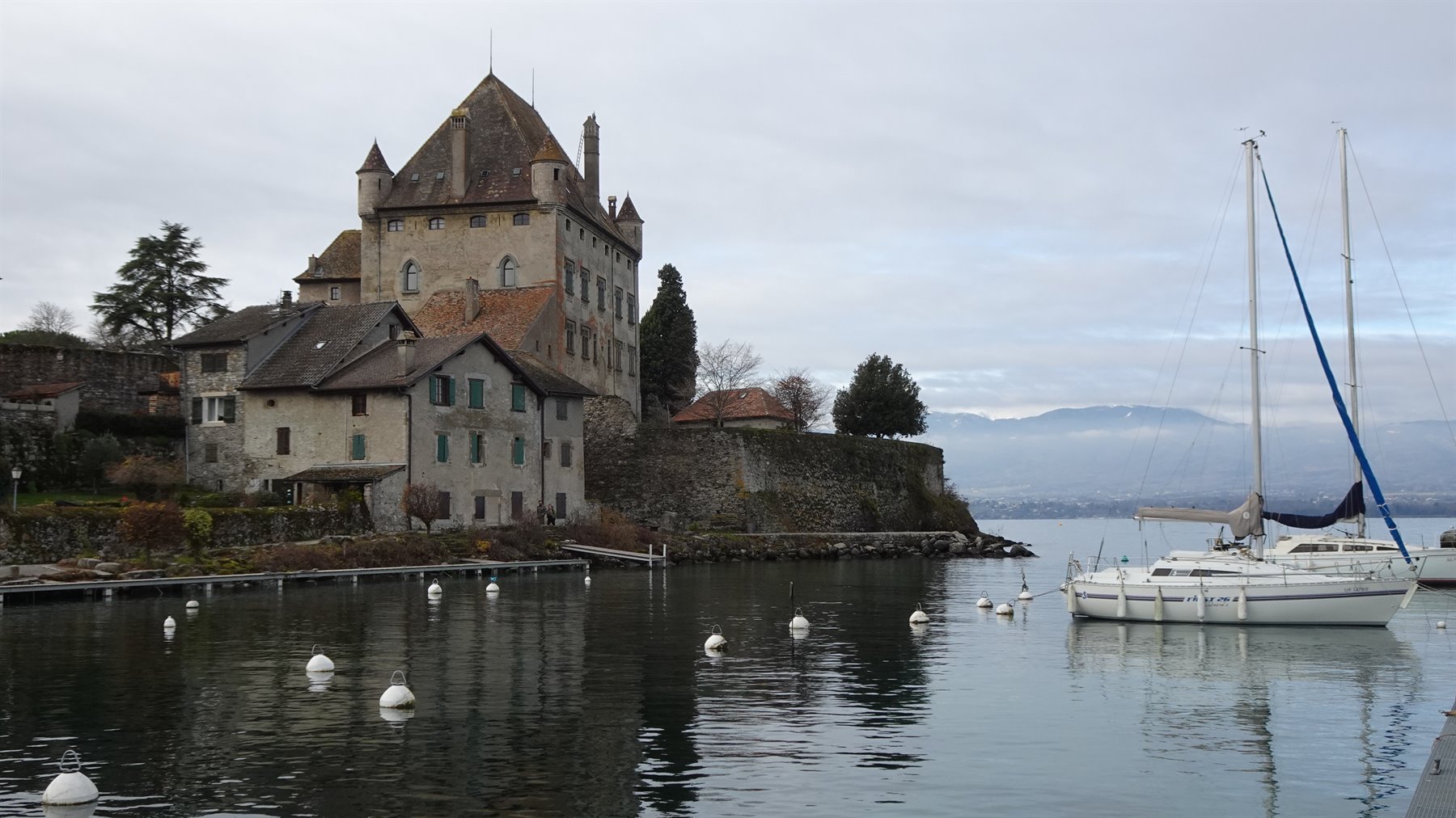 Il castello medievale di Yvoire sul lago con barche a vela ormeggiate