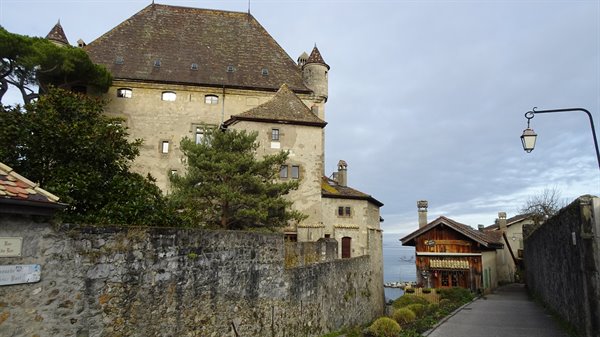 Medieval stone castle of Yvoire by the lake with narrow lane and lantern