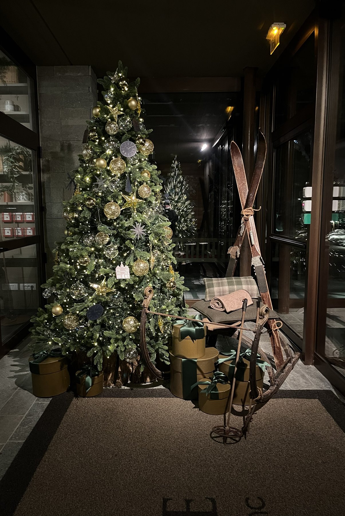 Albero di Natale addobbo con regali e sci d'epoca all'ingresso di un hotel a Chamonix