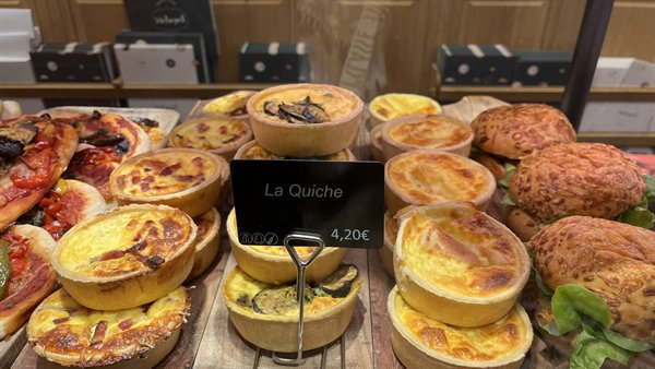 Display of savory quiches with "La Quiche" sign at 4.20€
