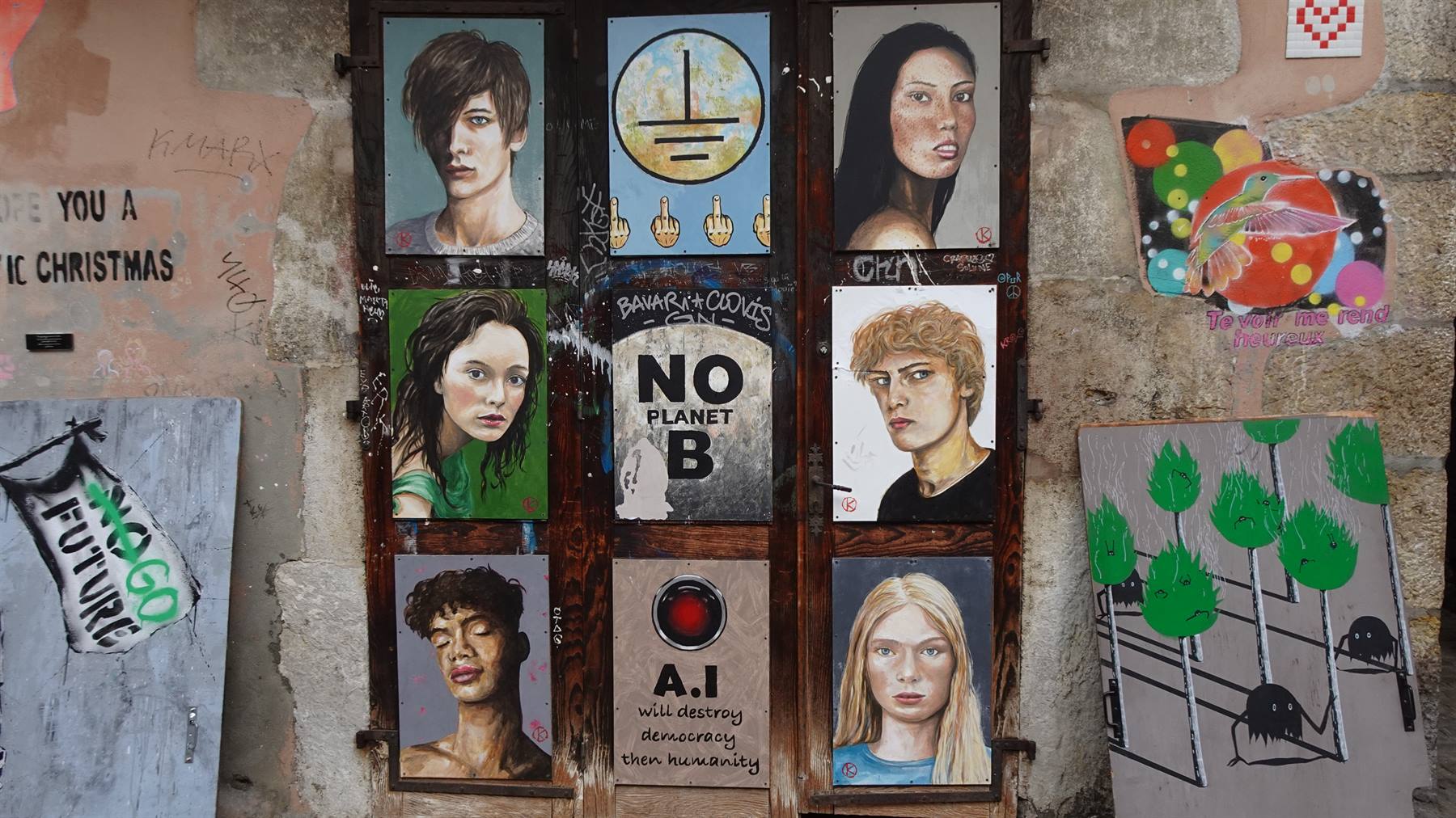 Ritratti urbani dipinti su legno e collage su muro di pietra, Yvoire