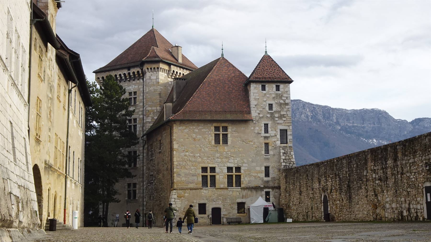 Castello di Annecy: torri in pietra e tetti ardesia, visitatori nel cortile