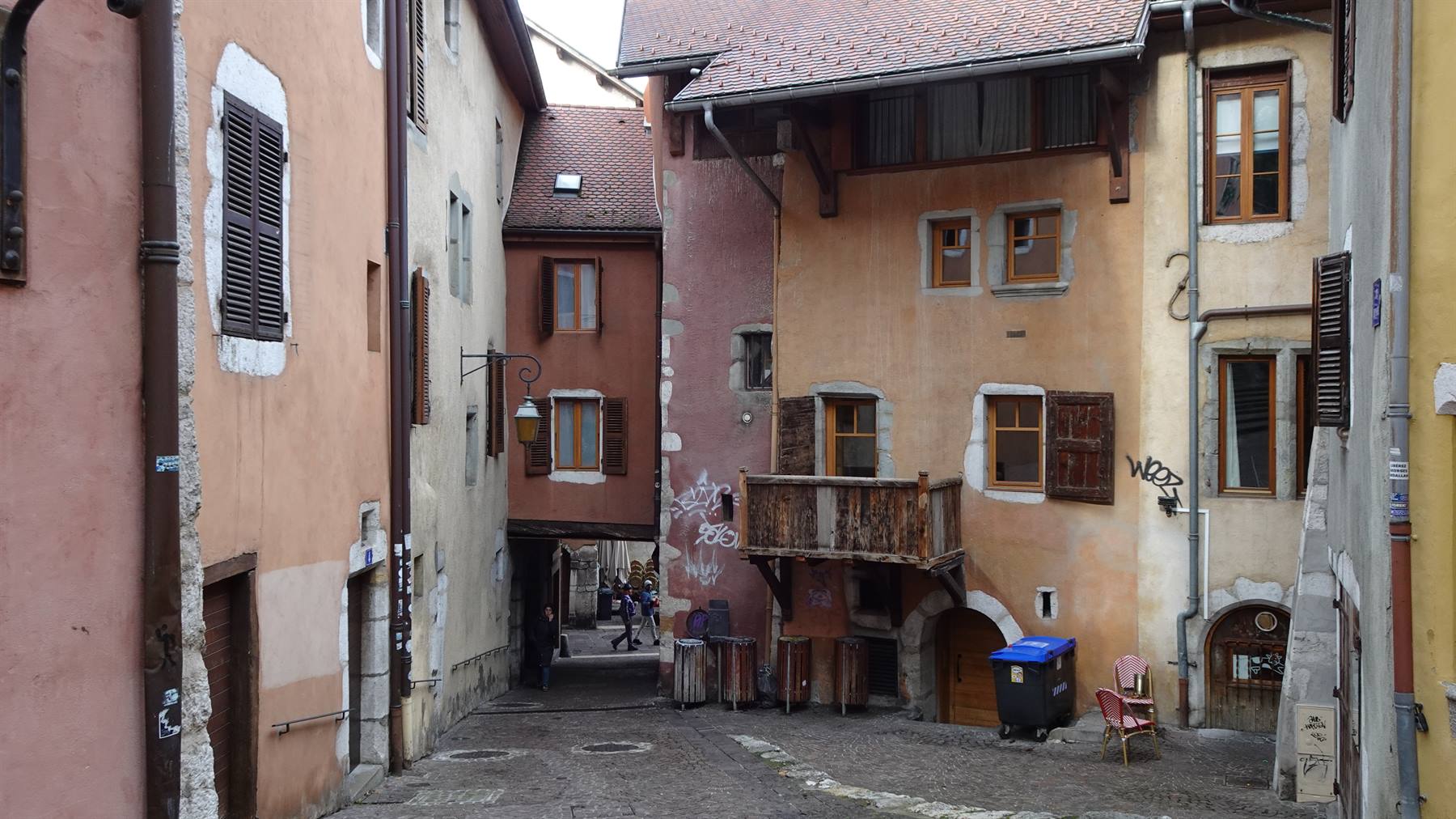 Vicolo acciottolato tra case medievali in pietra e intonaco color ocra, Annecy