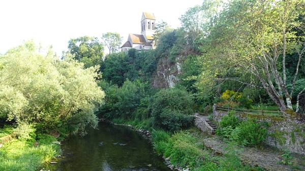 The church of Saint Céneri-le-Gérei overlooks the river among green trees