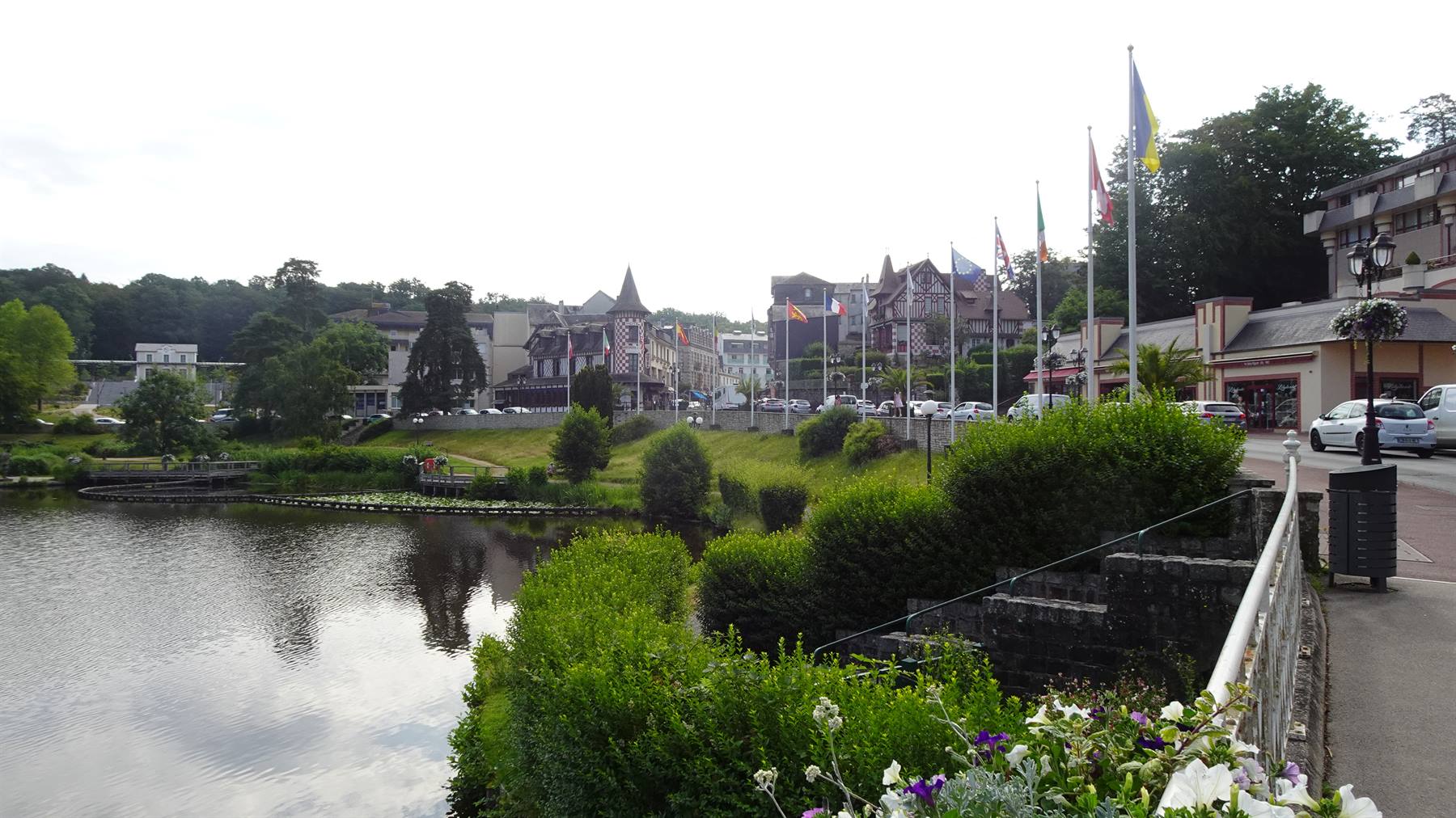 Lago con case a graticcio e bandiere nel centro di Bagnoles de l'Orne