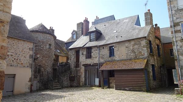 Medieval stone houses with spiral stair tower, cobbled courtyard, midday light