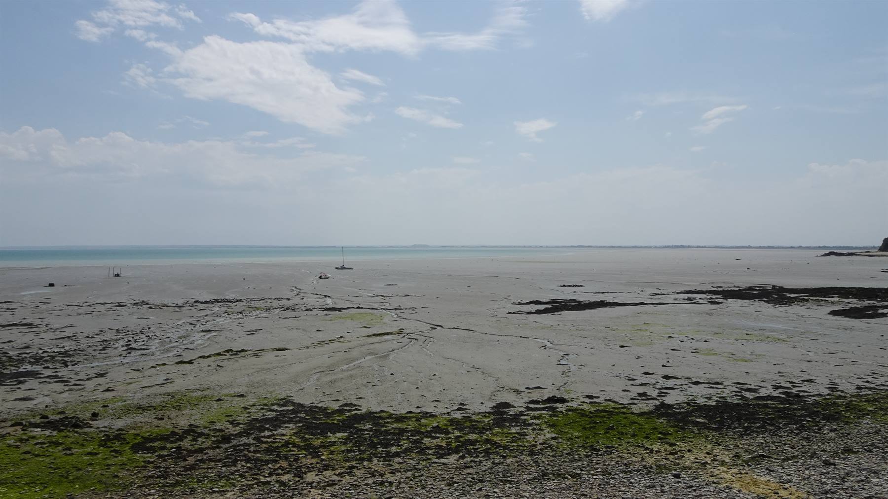 Bassa marea a Cancale: alghe e sabbia scoperte, barche lontane sul mare