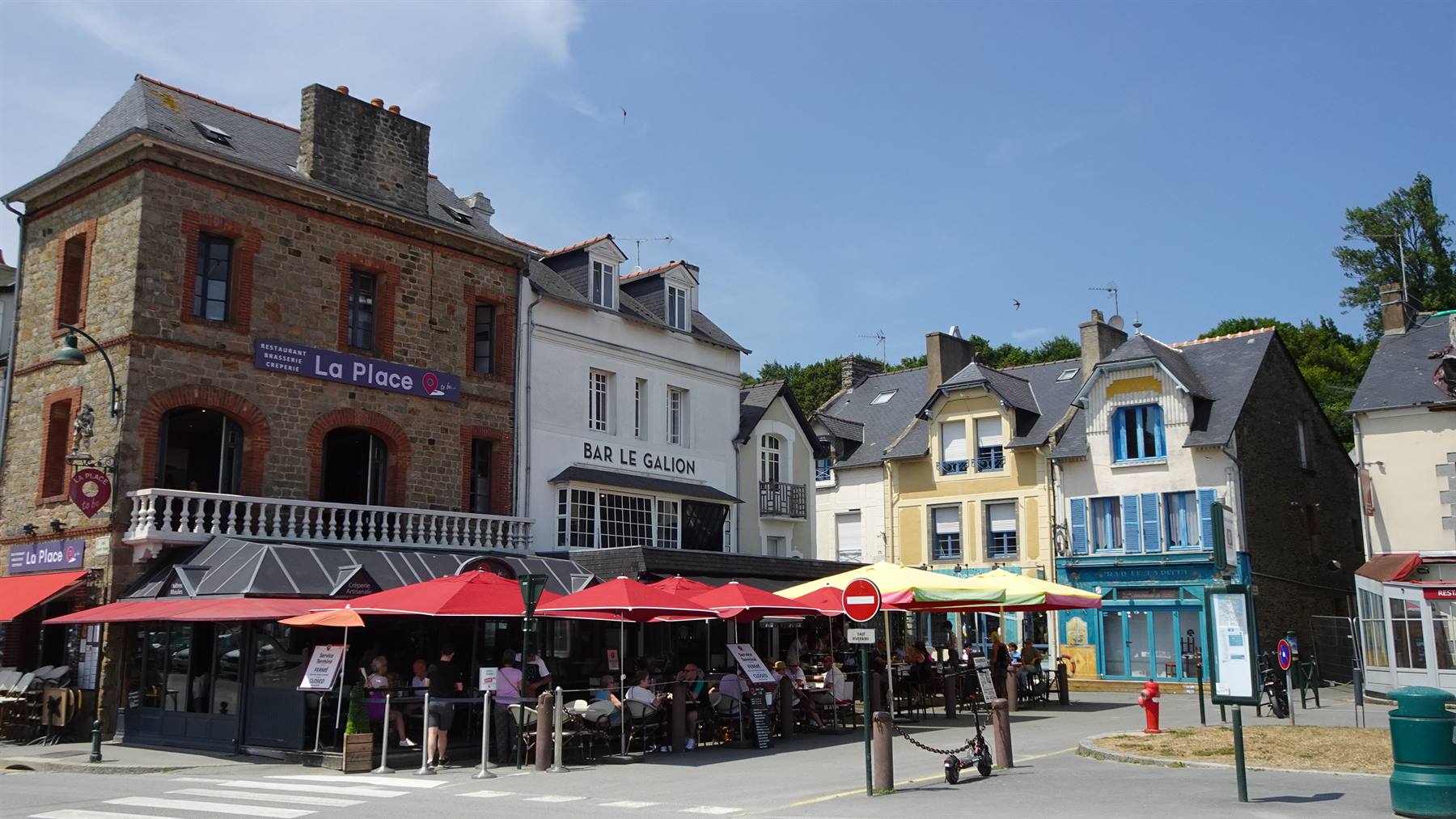 Bar Le Galion e caffè con ombrelloni rossi nella piazza di Cancale