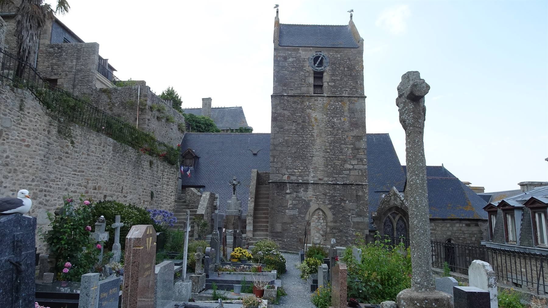 Cimitero con croci in pietra davanti alla chiesa di Mont Saint Michel