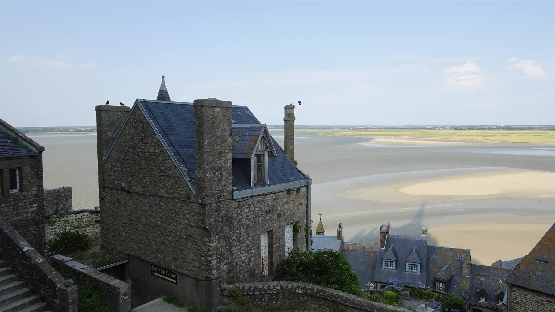 Case in pietra di Mont Saint Michel sulla baia sabbiosa in luce diurna