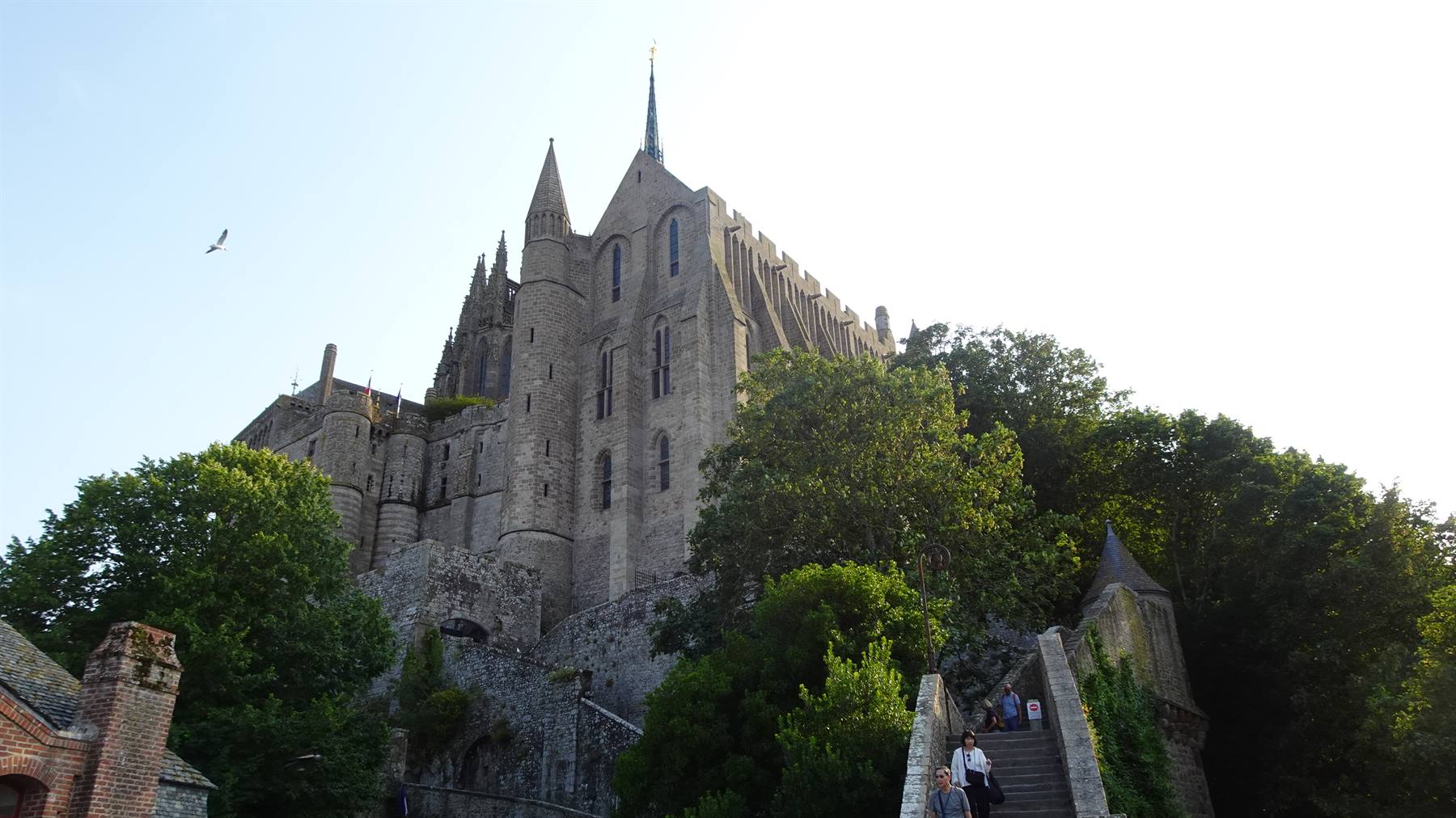 L'abbazia di Mont Saint Michel sale sulla roccia, turisti salono la scalinata