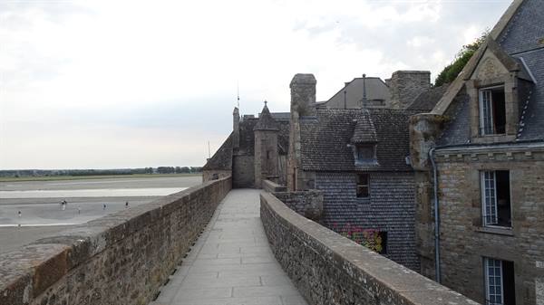 Stone rampart walk at Mont Saint Michel, slate houses above the bay