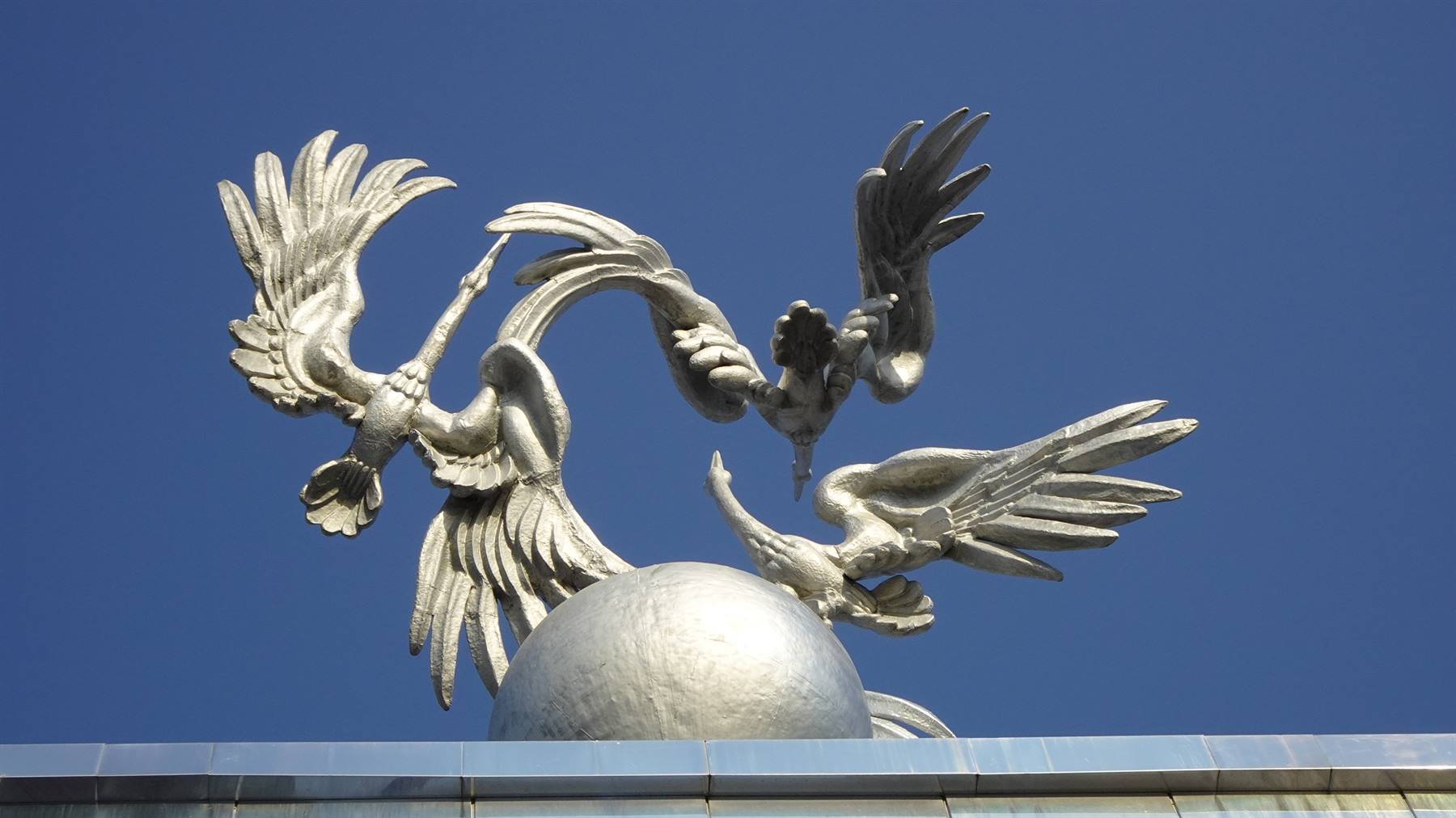 gru d'argento sul globo, simbolo nazionale, cielo blu a Tashkent