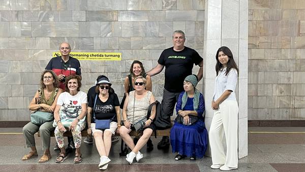 Il gruppo con la guida posa seduto nella metropolitana di Tashkent