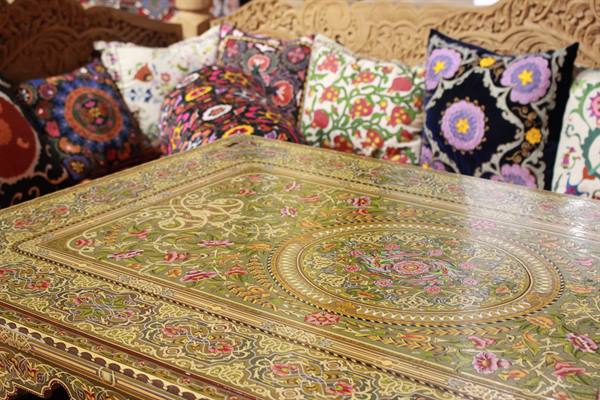 Tavolo intarsiato con motivi floreali e cuscini suzani colorati, Bukhara