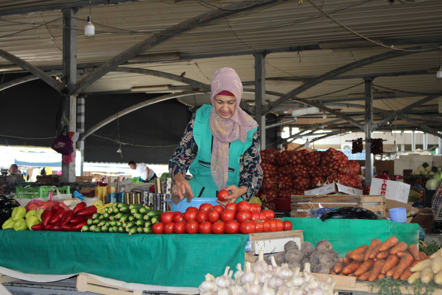 Venditrice al mercato di Chorsu a Tashkent, pomodori e peperoni freschi