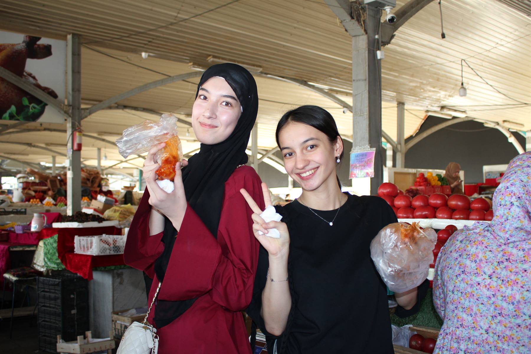 Due ragazze sorridenti con snack di frutta al mercato coperto di Chorsu, Tashkent