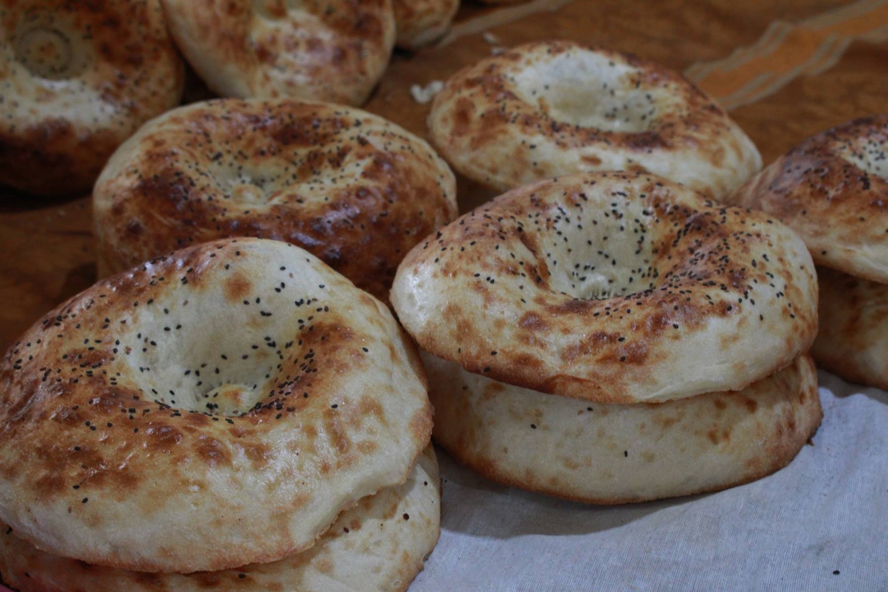 Pane tondo fresco con semi di sesamo sul banco del bazar di Samarcanda