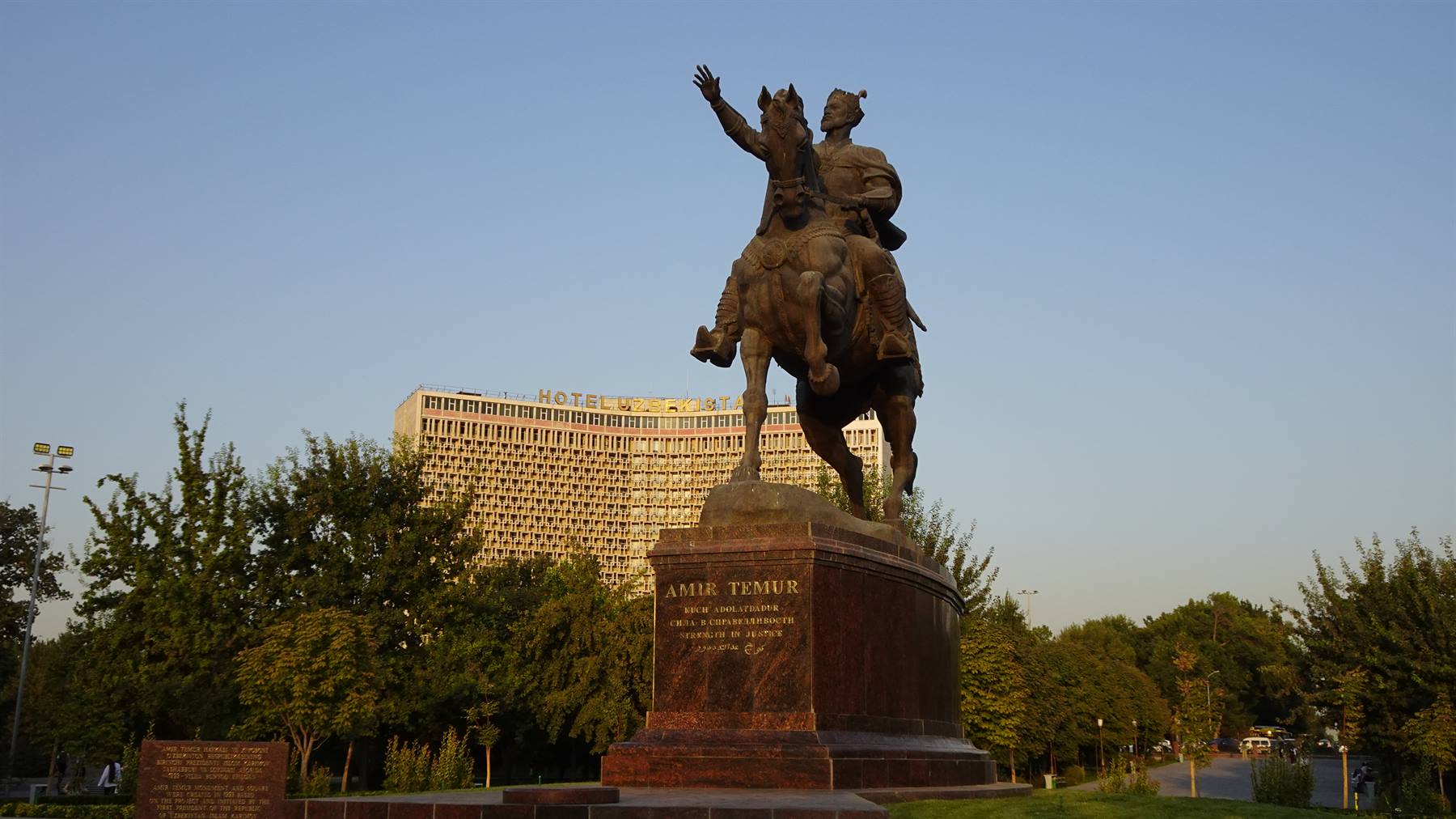 Statua equestre di Amir Temur a Tashkent, luce dorata tra gli alberi